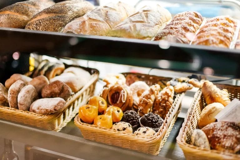 Wicker baskets of baked goods inside a display case.