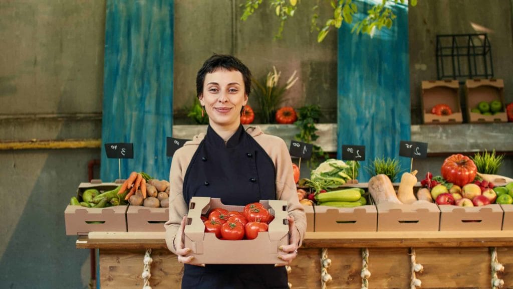 woman at farmers market holding tomatoes