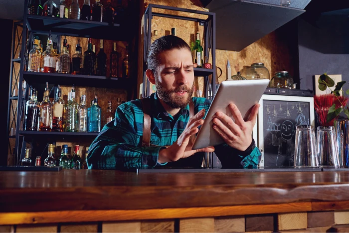 A bartender working on a tablet.