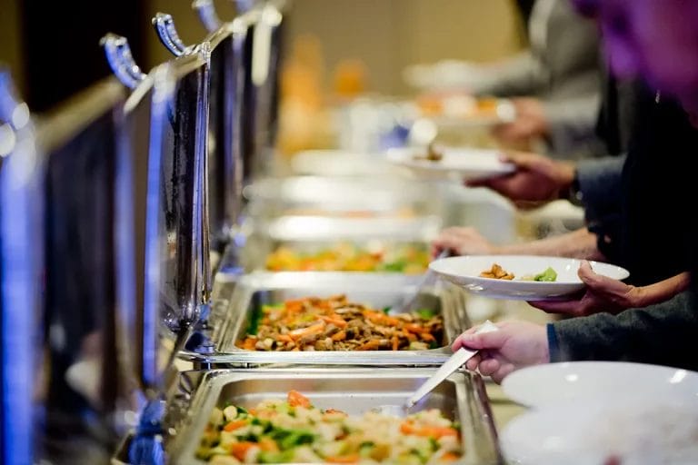 A catered buffet with appetizers and main courses in chafing dishes.