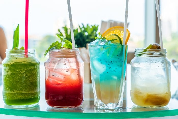 Four types of mocktails sitting on a tray.