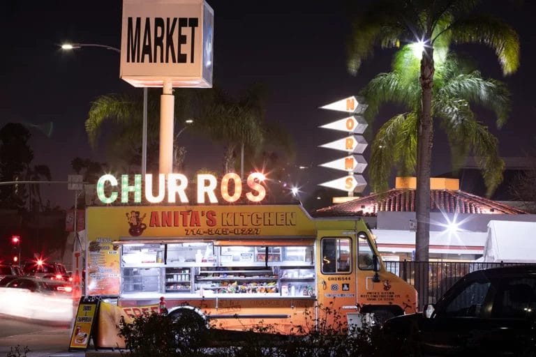 A food truck selling churros parked on a street at night in Santa Ana, California.