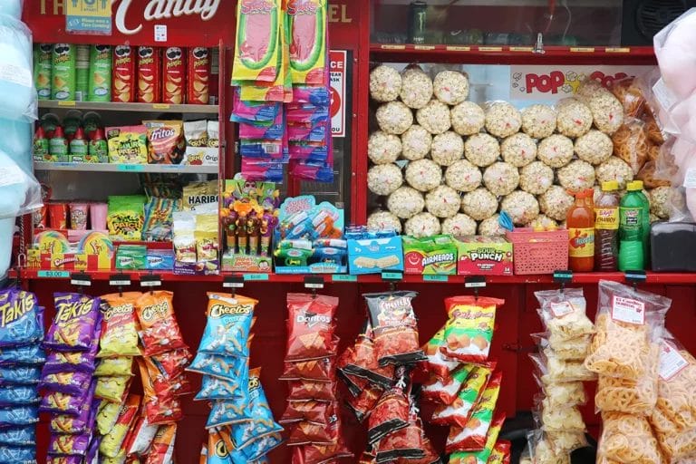 A concession stand containing rows of prepackaged snack foods, including popcorn, chips, and candy.
