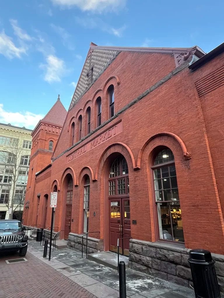 The facade of a red brick building reading "Central Market" and surrounded by patches of melting snow.