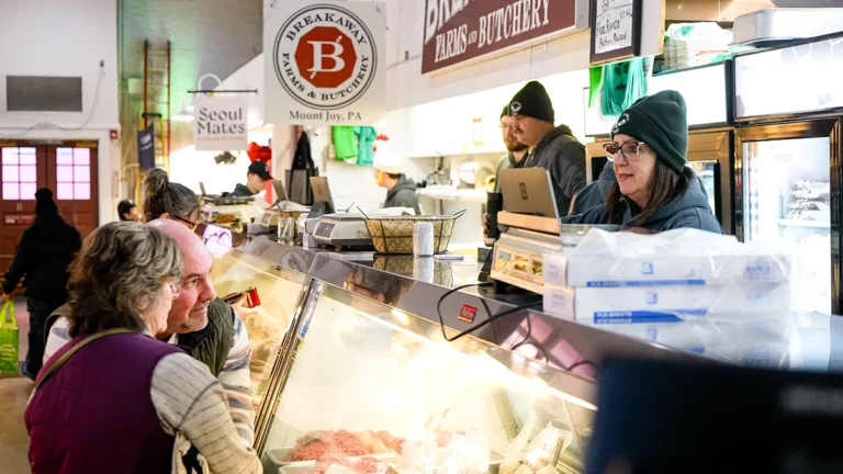 Two customers look into a display case at Lancaster Central Market.