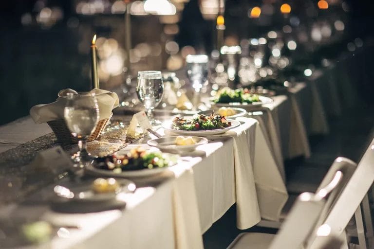 Plates of food laid out on a table at a wedding reception.