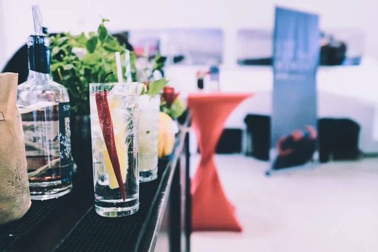 A close-up shot of cocktails along a bar at a convention.