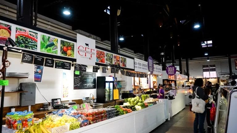 Neatly stacked cartons of berries and piles of produce line Charles Family Farm's booth at Lancaster Central Market.