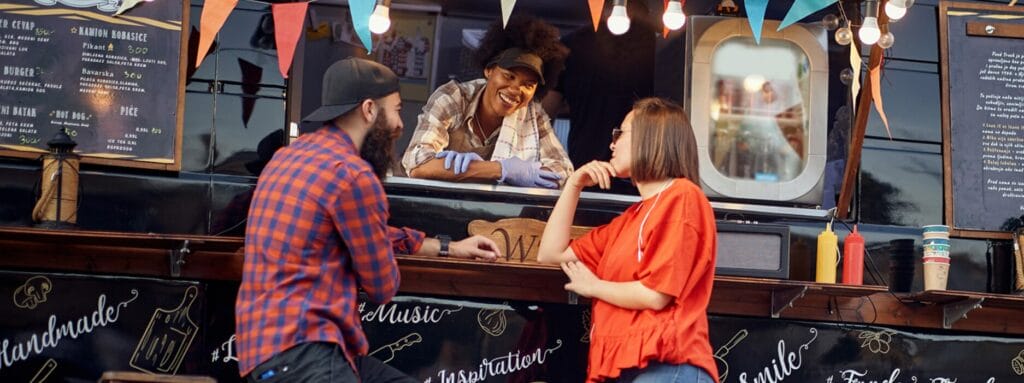 North Carolina food truck employee serving a couple.