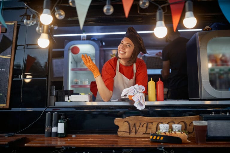 Female food truck worker posing at counter.